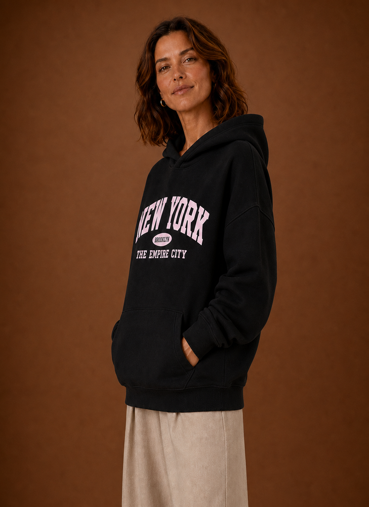 Side profile of oversized women's pullover hoodie showing hood and relaxed fit